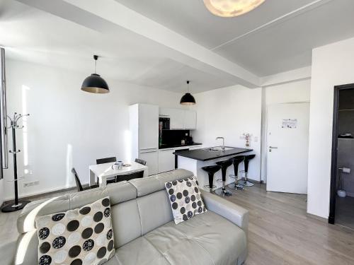a white living room with a couch and a kitchen at Brand new 2 BR Gambetta Fully Renovated 2021- 5 mns Palais by Olam Properties in Cannes