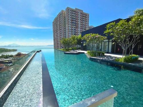 a infinity pool with a view of the water at Jovial Modern&Stylish `UrbanSuites in Jelutong
