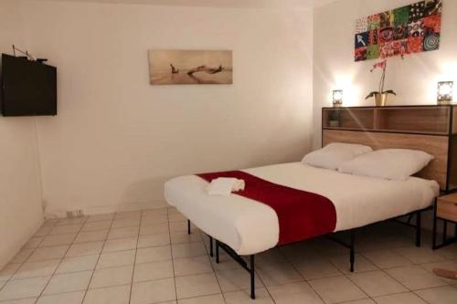 1 dormitorio con 1 cama y TV en Appartement au calme ORSAY PARIS, en Orsay