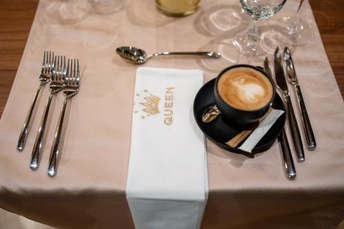 a table topped with a cup of coffee and silverware at Queen of Zlatibor in Zlatibor