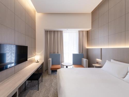 福岡市にあるHOTEL IL PALAZZO - Vacation STAY 68259vの大型ベッドとテレビが備わるホテルルームです。