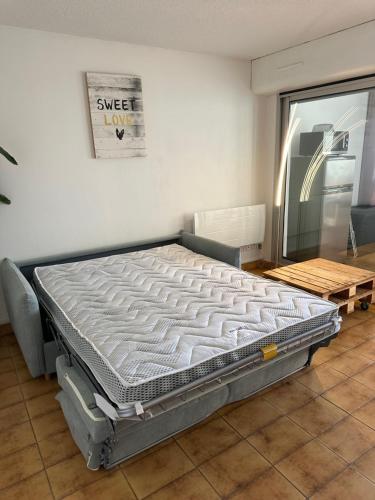 - un lit dans une pièce à côté d'une fenêtre dans l'établissement HELiOS, au Cap d'Agde