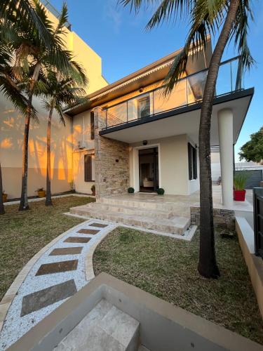 uma casa na praia com palmeiras em Villa Anna Lucia & sa dépendance em Saint-Pierre
