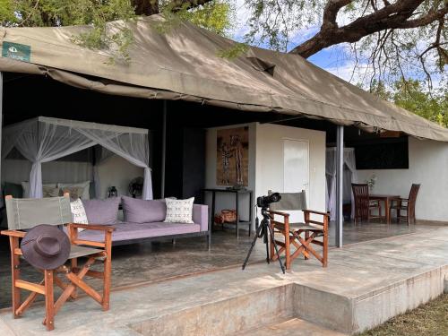 a photographer taking a picture of a house with a tent at Msandile River Lodge in Kakumbi