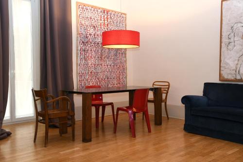 uma mesa de jantar com cadeiras e um candeeiro vermelho em Casa Cammarota em Nápoles