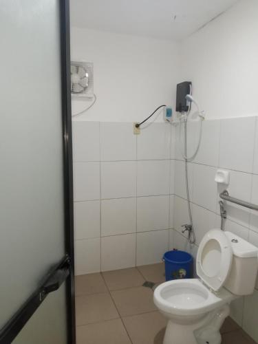 a bathroom with a toilet with a phone on the wall at Raje Residence in El Nido