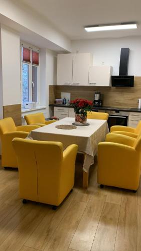 a kitchen with a table and yellow chairs at Ferienwohnung Nähe Stadtpark, 4 Schlafzimmer, 2 Bäder, Terrasse, Parkplatz - Wohnung 1 in Erfurt