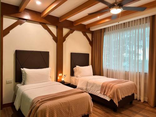 a bedroom with two beds and a window at Lee Boutique Hotel Baguio in Baguio