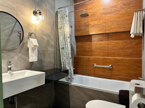 a bathroom with a sink and a tub and a mirror at Lee Boutique Hotel Baguio in Baguio