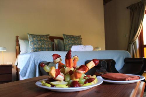 a plate of fruit and vegetables on a table at Mologa River Lodge in Rust de Winter