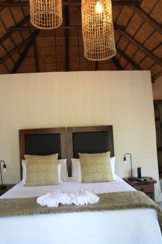 a bedroom with a bed with towels on it at Mologa River Lodge in Rust de Winter