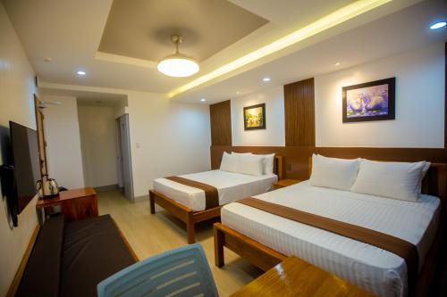 a hotel room with two beds and a chair at Horizon Hotel Romblon in Romblon