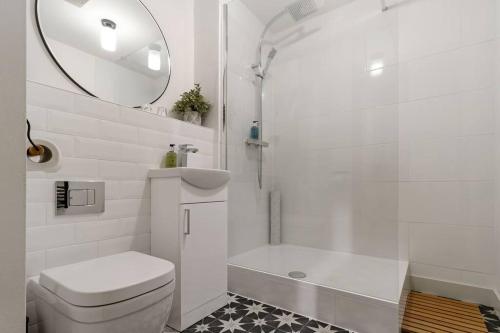 e bagno con servizi igienici, doccia e specchio. di Central 1BD with Free Underground Parking! a Cheltenham