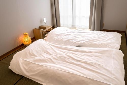 1 dormitorio con 2 camas blancas y ventana en marugame stop - Vacation STAY 86888v, en Marugame