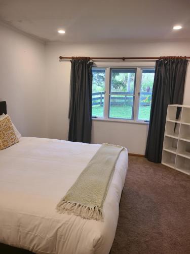 ein Schlafzimmer mit einem großen Bett und einem Fenster in der Unterkunft Te Papatapu Retreat in Raglan