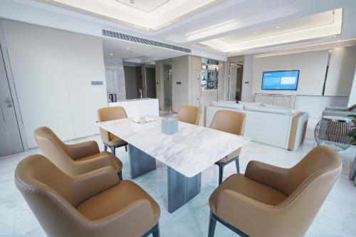 a dining room with a white table and chairs at Wyndham Shaoxing Keqiao in Shaoxing