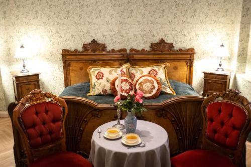 - une chambre avec un lit, une table et deux chaises dans l'établissement Jaunmoku Palace Complex Hotel, à Tume
