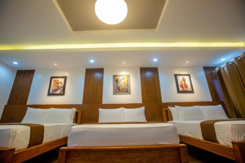 a bedroom with two beds with white sheets at Horizon Hotel Romblon in Romblon