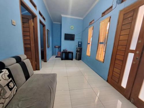 un soggiorno con pareti blu e divano di Home stay asri a Kamparganya