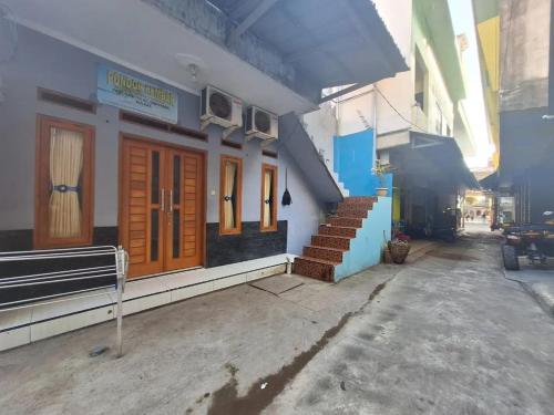 un edificio con porte arancioni e scale su una strada di Home stay asri a Kamparganya
