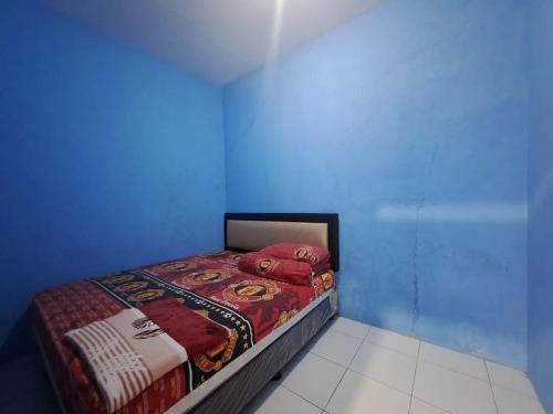 una camera con un letto in una camera blu di Home stay asri a Kamparganya