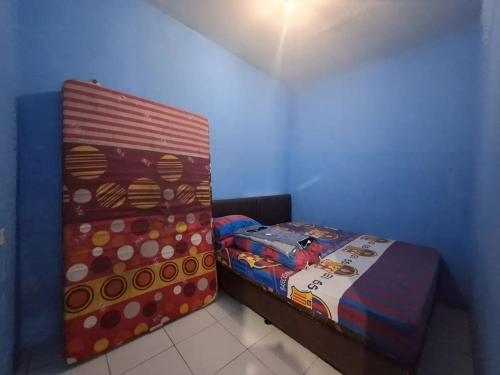una piccola camera da letto con un letto e un piumone di Home stay asri a Kamparganya