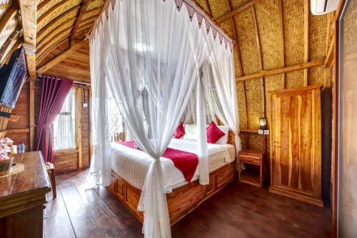 ペニダ島にあるSanten Beach Bungalowsの木製キャビン内のベッドルーム1室(天蓋付きベッド1台付)