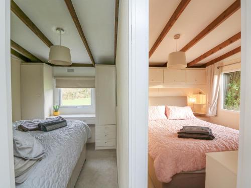 a small bedroom with two beds and a window at Riverside Rest in Builth Wells