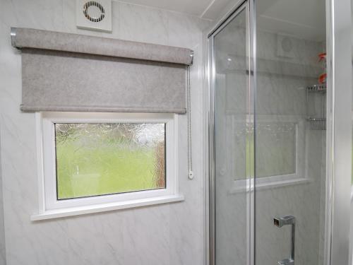 a shower with a window in a bathroom at Riverside Rest in Builth Wells