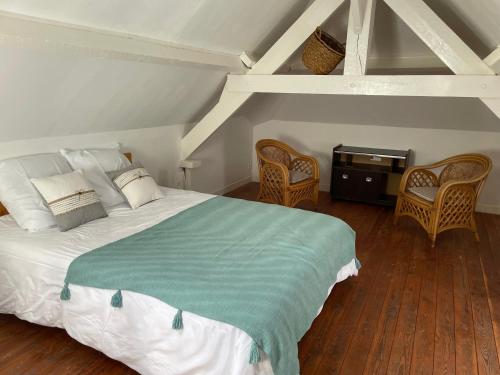 une chambre avec un lit avec deux chaises et une table dans l'établissement Maison gîte 2/4 P baie du mont, à Pontorson