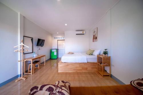 um quarto com uma cama e uma secretária num quarto em The kn kohlarn resort em Ko Larn