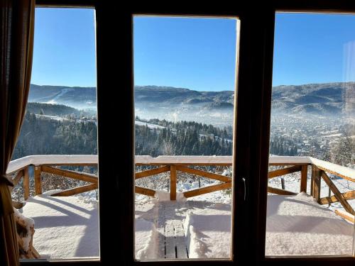 a view of a snow covered mountain from a window at Vikendica Tromedja Pale in Pale