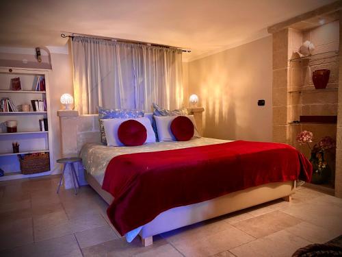 Schlafzimmer mit einem Bett mit roten und weißen Kissen in der Unterkunft Le Dimore in Piazzetta in Massafra