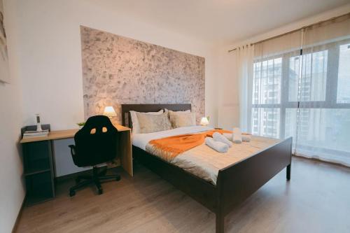 a bedroom with a bed and a desk and a chair at Plaza View in Bucharest