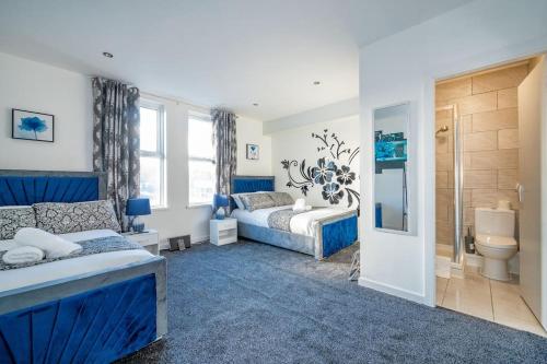 ein blau-weißes Schlafzimmer mit einem Bett und einem Badezimmer in der Unterkunft *372kr* For your most relaxed & Cosy stay + Free Parking + Free Fast WiFi * in Headingley