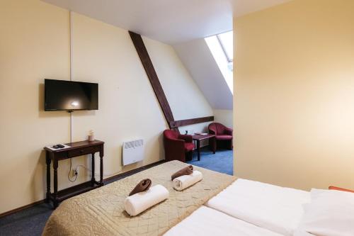 a bedroom with a bed with two towels on it at Jaunmoku Palace Complex Hotel in Tume