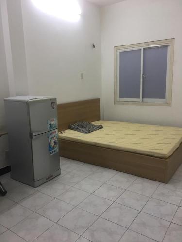 a room with two beds and a refrigerator in it at Perfect House in Ho Chi Minh City
