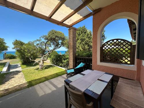 a table and chairs on a patio with a view of the water at Genari Beach Apartments in Levendokhórion