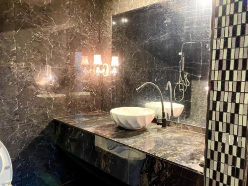 a black bathroom with a sink and a mirror at Family's Homestay in Kuala Terengganu