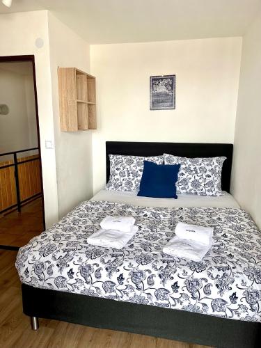 a bedroom with a bed with a black and white comforter at Penzion POSADA in Podivín