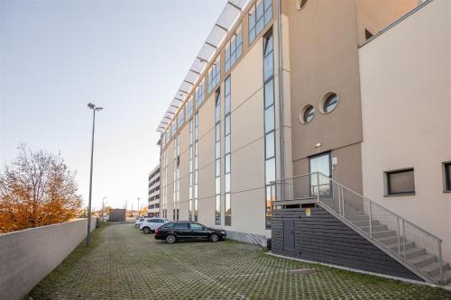 un coche aparcado en un aparcamiento al lado de un edificio en Noventa Hotel, en Noventa di Piave