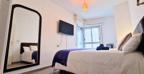 - une chambre avec un grand lit et un miroir dans l'établissement SANXENXO , apartamento nuevo 300 mts playa Silgar, à Sanxenxo