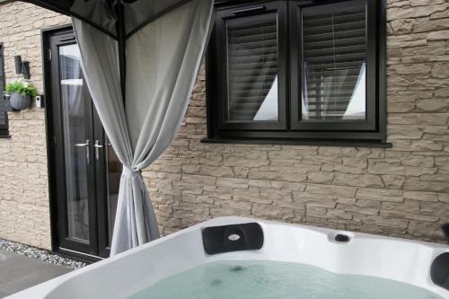 a bath tub in front of a building with a window at Terfyn Hall holiday Apartment 2 in Prestatyn