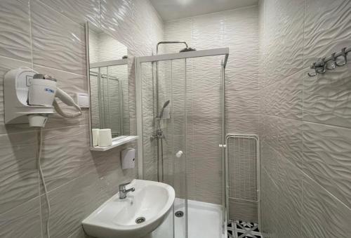 y baño con lavabo y ducha acristalada. en VIP apart 771 en Tiflis