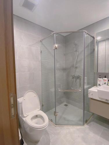 a bathroom with a shower with a toilet and a sink at Bunny Bliss-Service Apartment in Hanoi