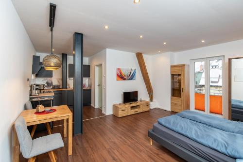 a bedroom with a bed and a desk and a kitchen at Ferienwohnungen An den SchwabachAuen - Keine Monteure in Eckental