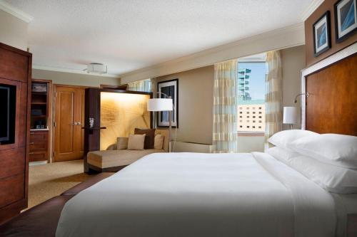 sypialnia z dużym białym łóżkiem i kanapą w obiekcie The Lincoln Marriott Cornhusker Hotel w mieście Lincoln