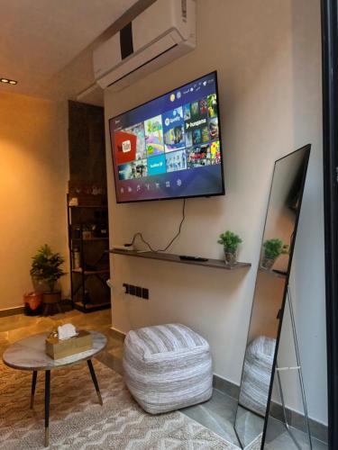 een woonkamer met een flatscreen-tv aan de muur bij شقة بدخول ذاتي وجلسة خارجية Midnight Apartment in Riyad