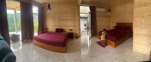 a woman sitting in a room with two beds at Country Homes in Ella