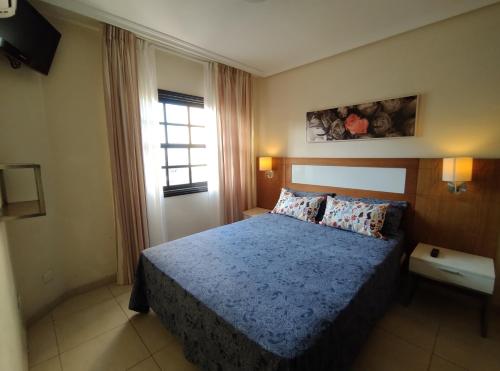 サンミゲル・デ・アボナにあるBiB Pool Side Apartment & Ocean Viewのベッドルーム1室(青いベッドカバー、窓付)